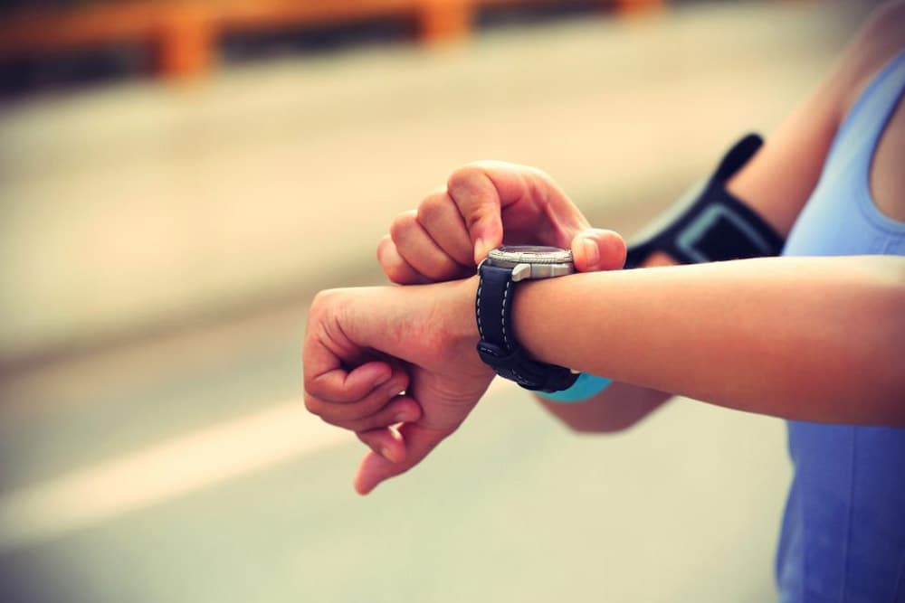 Fast Approval Loans - A woman jogging outside setting her stopwatch